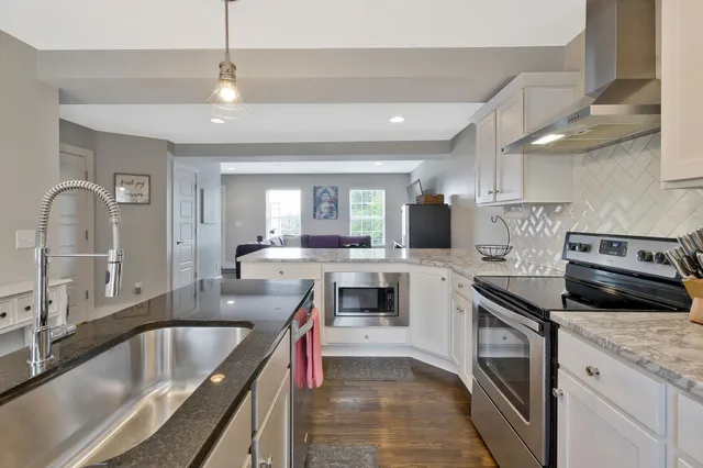 a kitchen with granite countertop a sink stainless steel appliances and cabinets