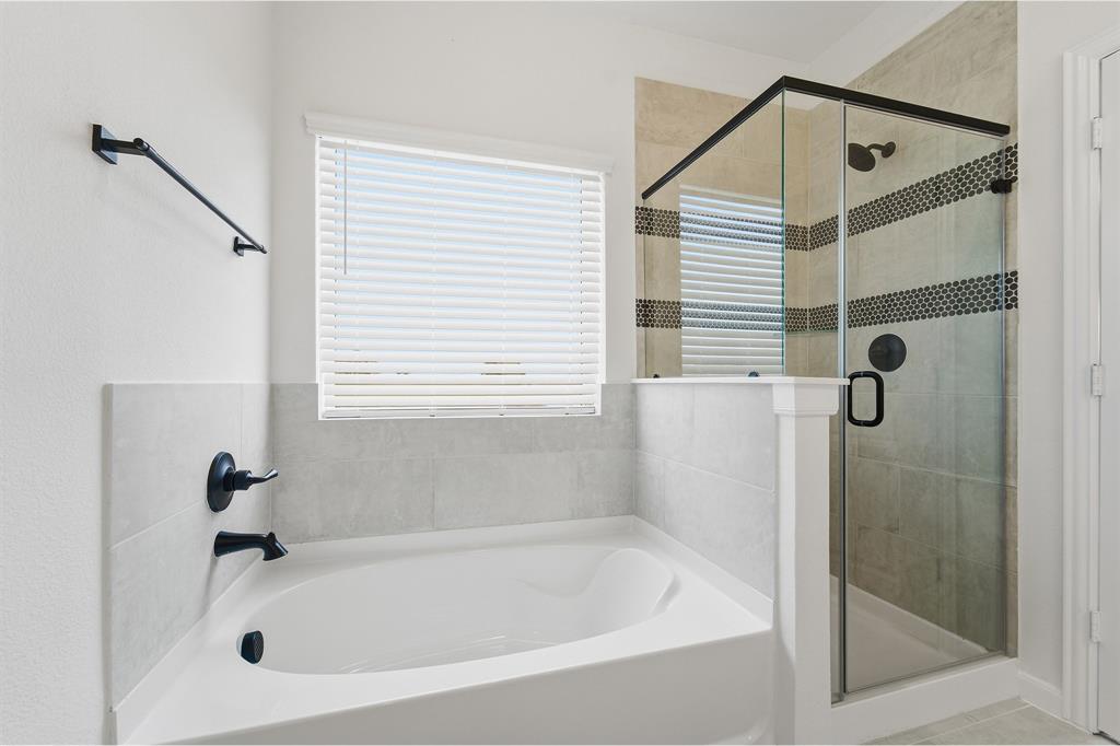 228 Charismatic Road Waxahachie, TX 75165 - Photo 15 of 23 a white bath tub sitting next to a white sink and a shower