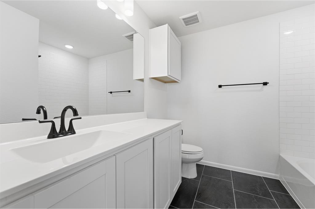 228 Charismatic Road Waxahachie, TX 75165 - Photo 21 of 23 a bathroom with a sink a toilet and a mirror