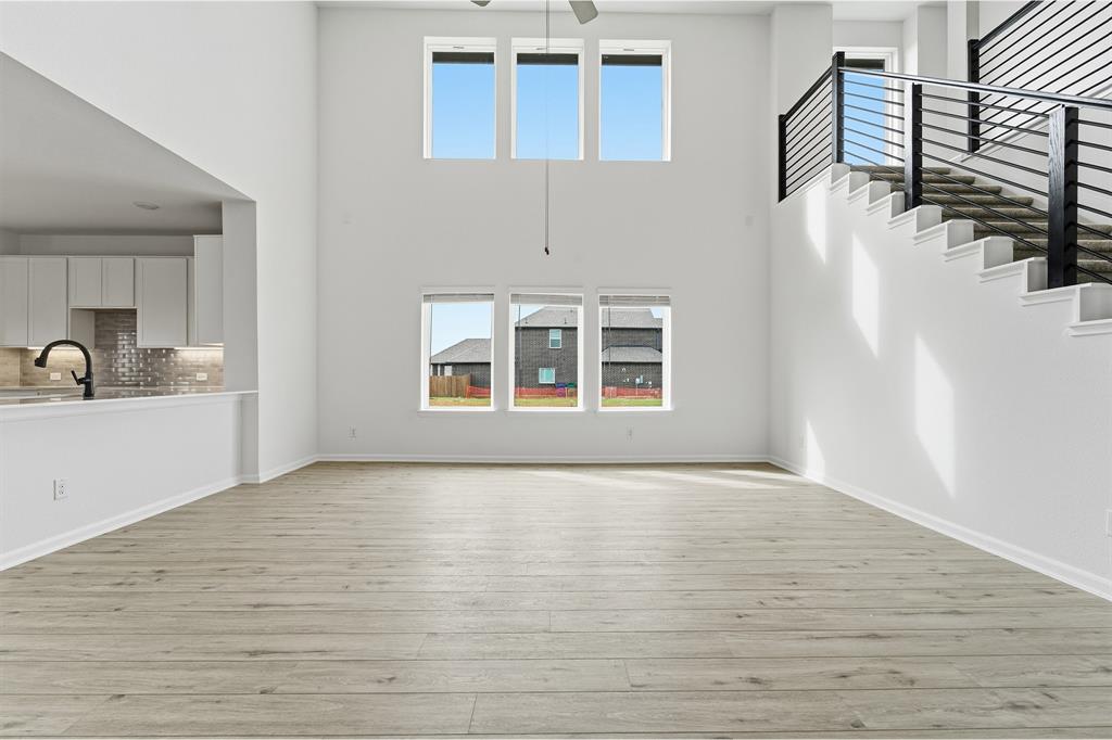 228 Charismatic Road Waxahachie, TX 75165 - Photo 5 of 23 a view of an empty room with wooden floor and a window