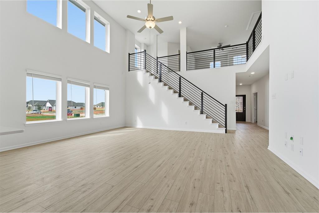 228 Charismatic Road Waxahachie, TX 75165 - Photo 7 of 23 a view of an empty room with wooden floor and a window