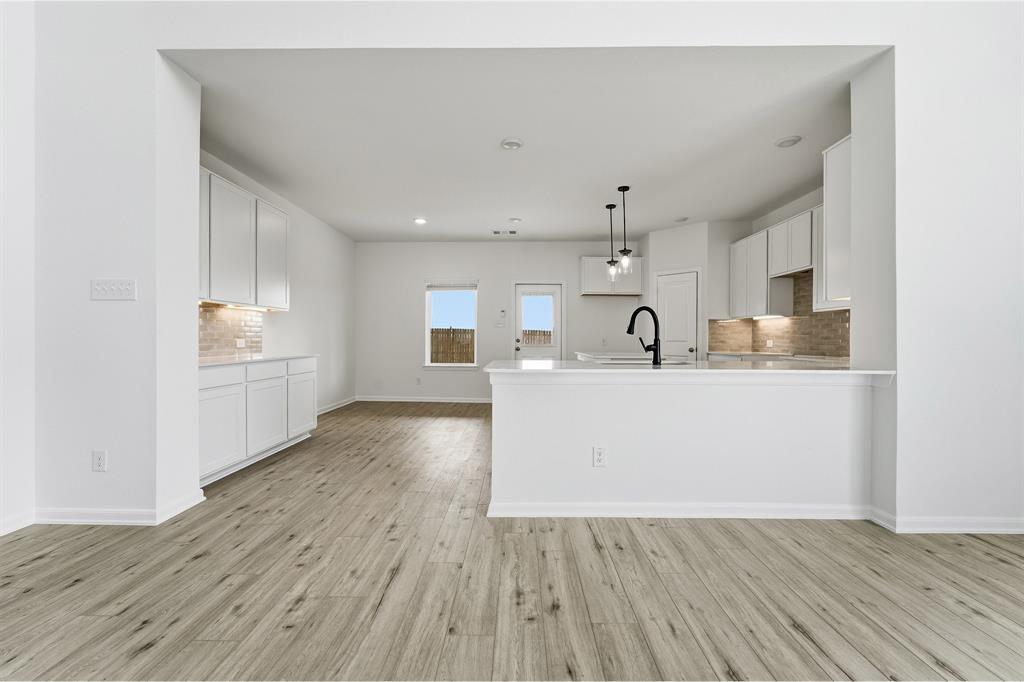 228 Charismatic Road Waxahachie, TX 75165 - Photo 8 of 23 a view of a kitchen with wooden floor and a sink