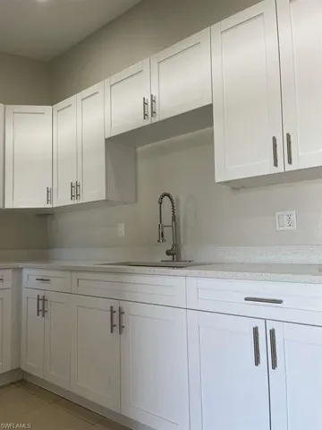 a close view of a sink cabinets and a window