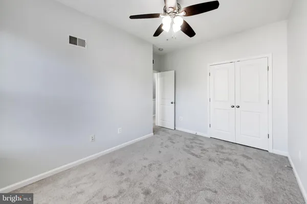 an empty room with chandelier fan