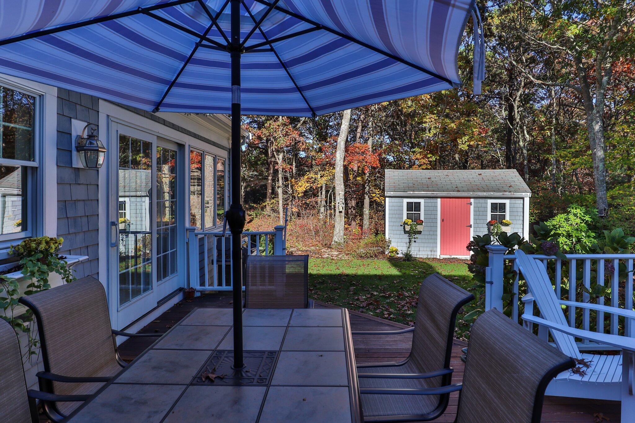 15 Regatta Drive Mashpee, MA 02649 - Photo 46 of 55 a patio with a table and chairs under an umbrella