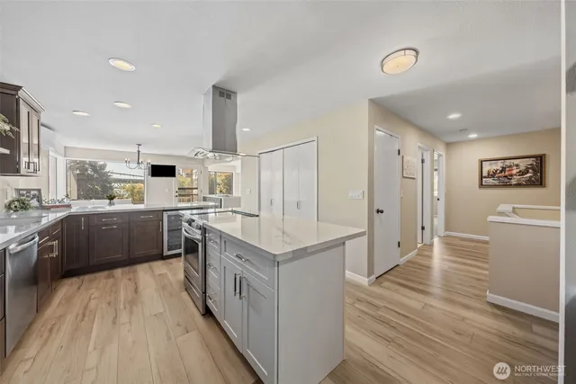 a large white kitchen with a sink and refrigerator