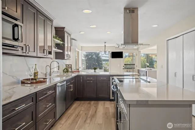 a kitchen with kitchen island granite countertop a sink and a stove