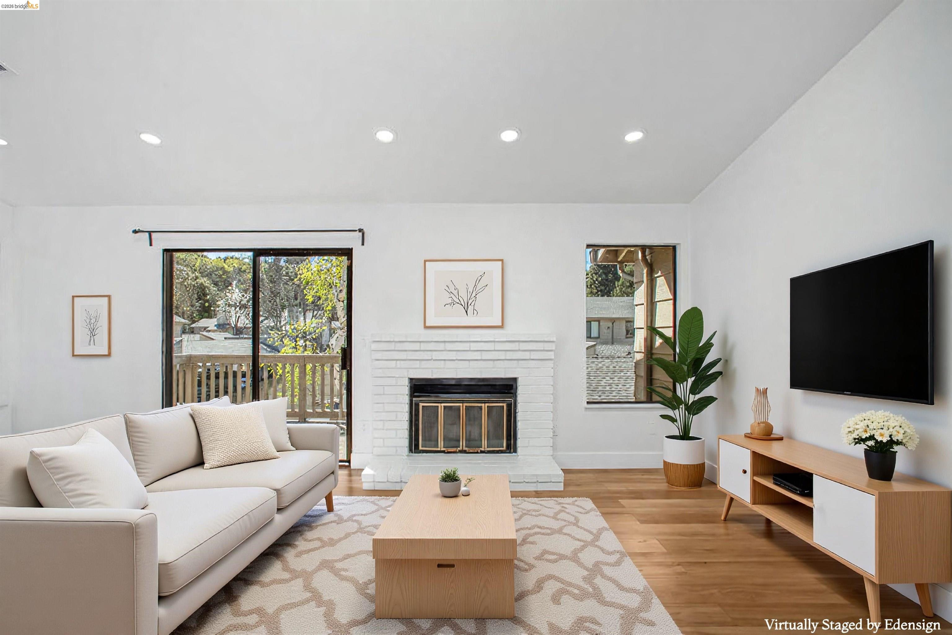 a living room with furniture a flat screen tv and a fireplace