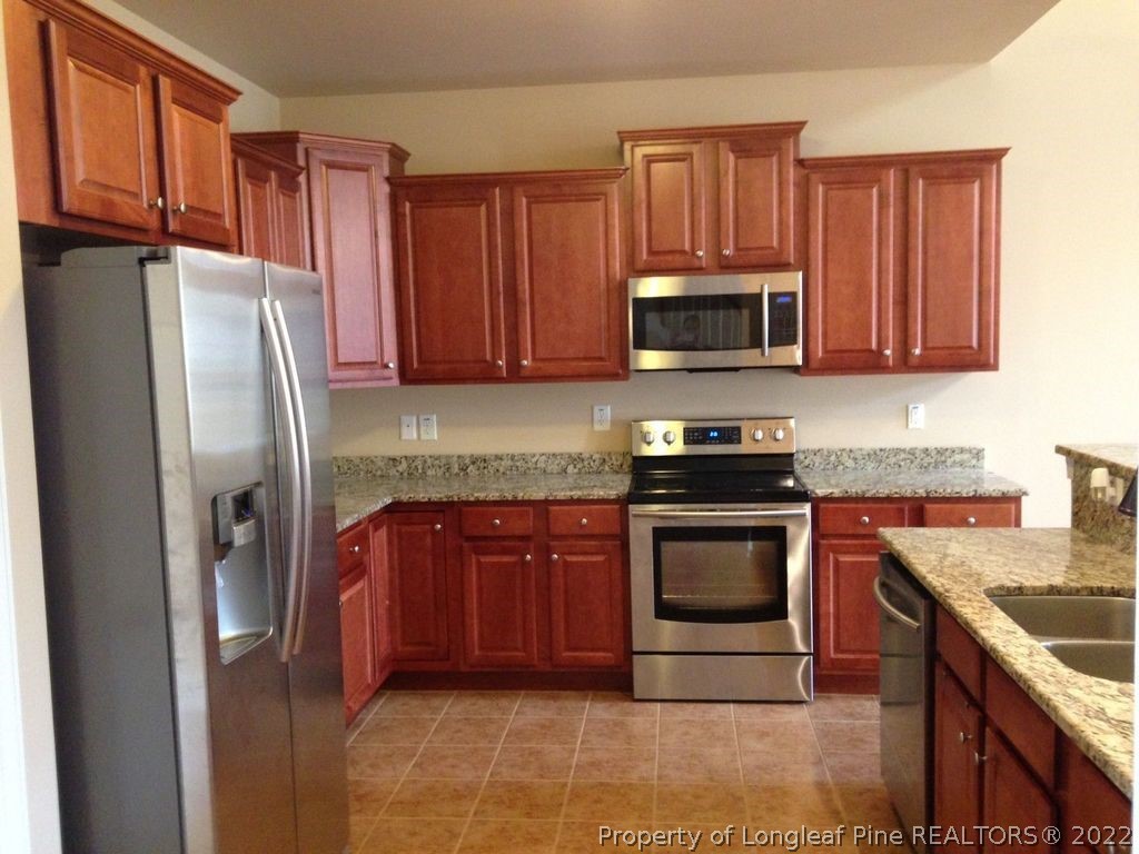 28 Hawk Ridge Drive Spring Lake, NC 28390 - Photo 3 of 5 a kitchen with granite countertop a refrigerator stove and microwave