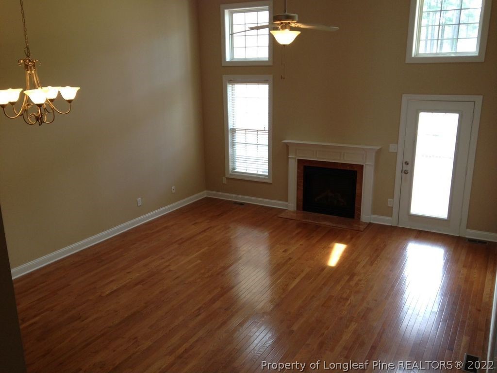 28 Hawk Ridge Drive Spring Lake, NC 28390 - Photo 4 of 5 an empty room with wooden floor chandelier and windows
