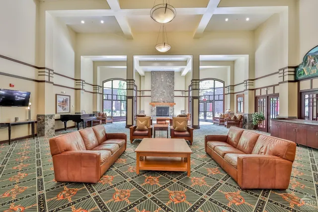 a living room with furniture fireplace and a large window