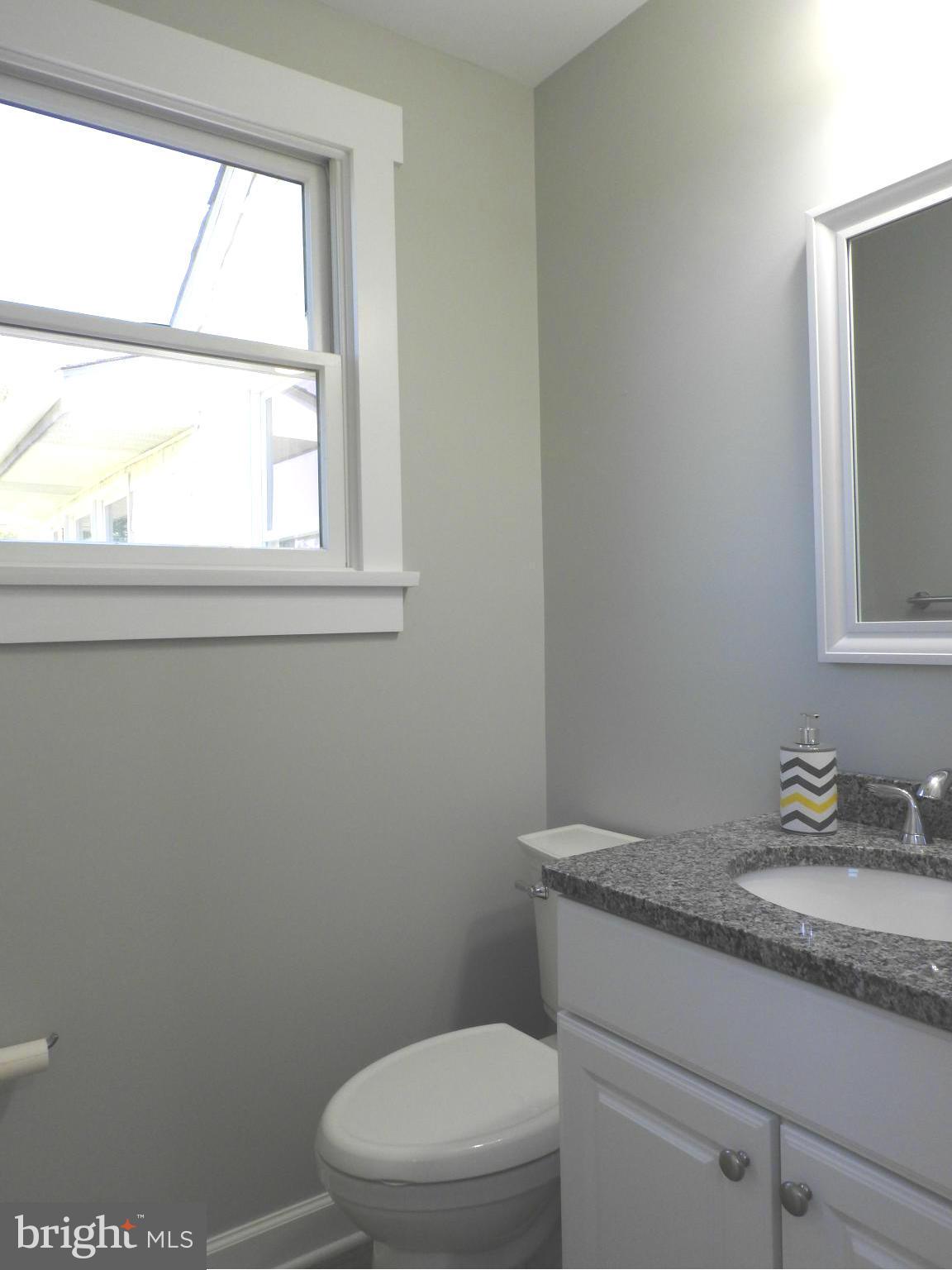 1540 Deep Point Road Woolford, MD 21677 - Photo 17 of 30 a bathroom with a granite countertop toilet a sink and a window