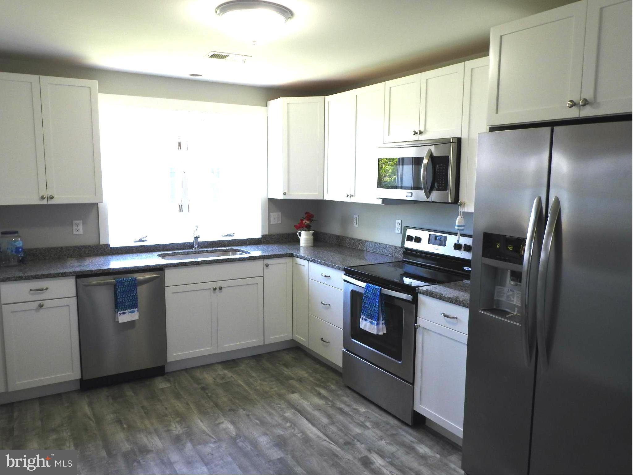1540 Deep Point Road Woolford, MD 21677 - Photo 7 of 30 a kitchen with stainless steel appliances granite countertop a sink a stove a refrigerator a microwave and cabinets