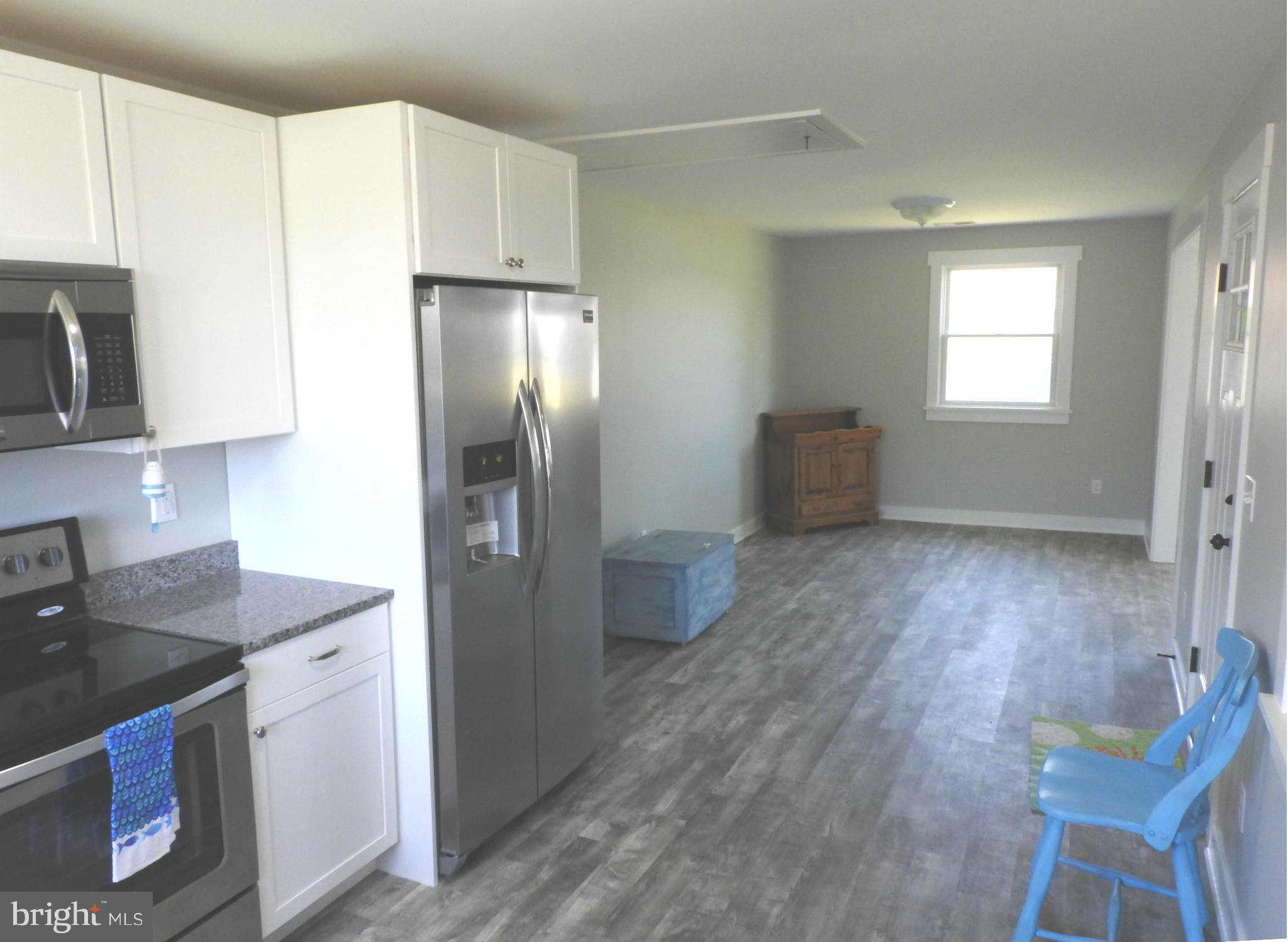 1540 Deep Point Road Woolford, MD 21677 - Photo 9 of 30 a kitchen with stainless steel appliances granite countertop a refrigerator a sink a stove and white cabinets with wooden floor