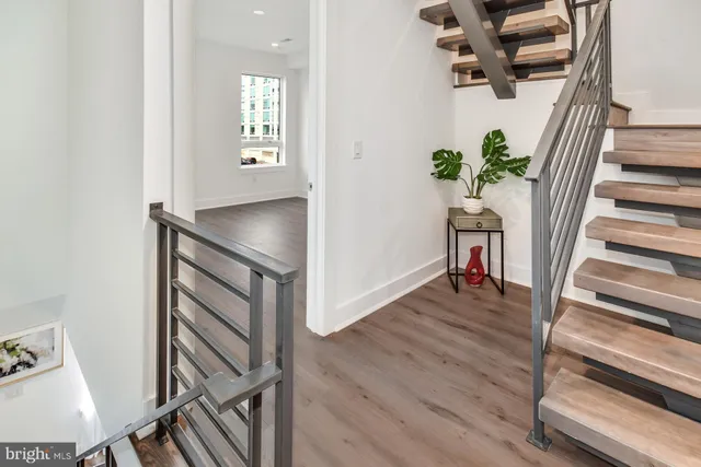 a view of a hallway with wooden floor and stairs
