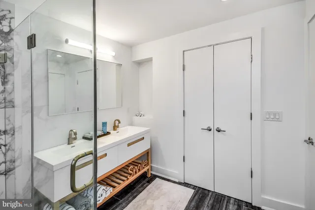 a bathroom with a sink a mirror and a shower