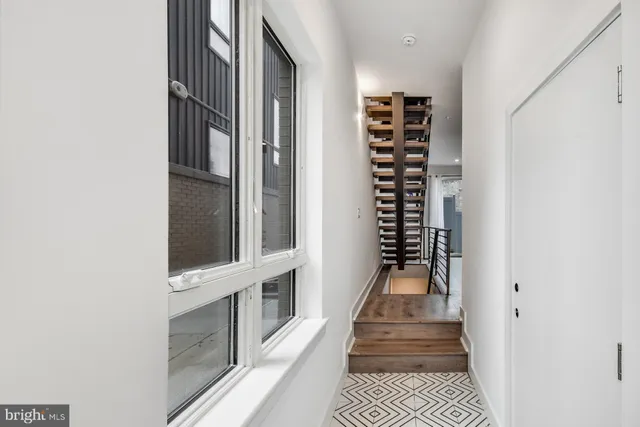 a view of a hallway with wooden floor and staircase
