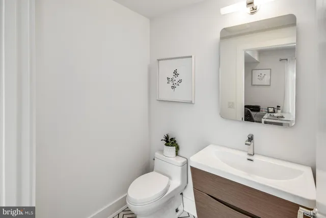 a bathroom with a toilet a sink and mirror