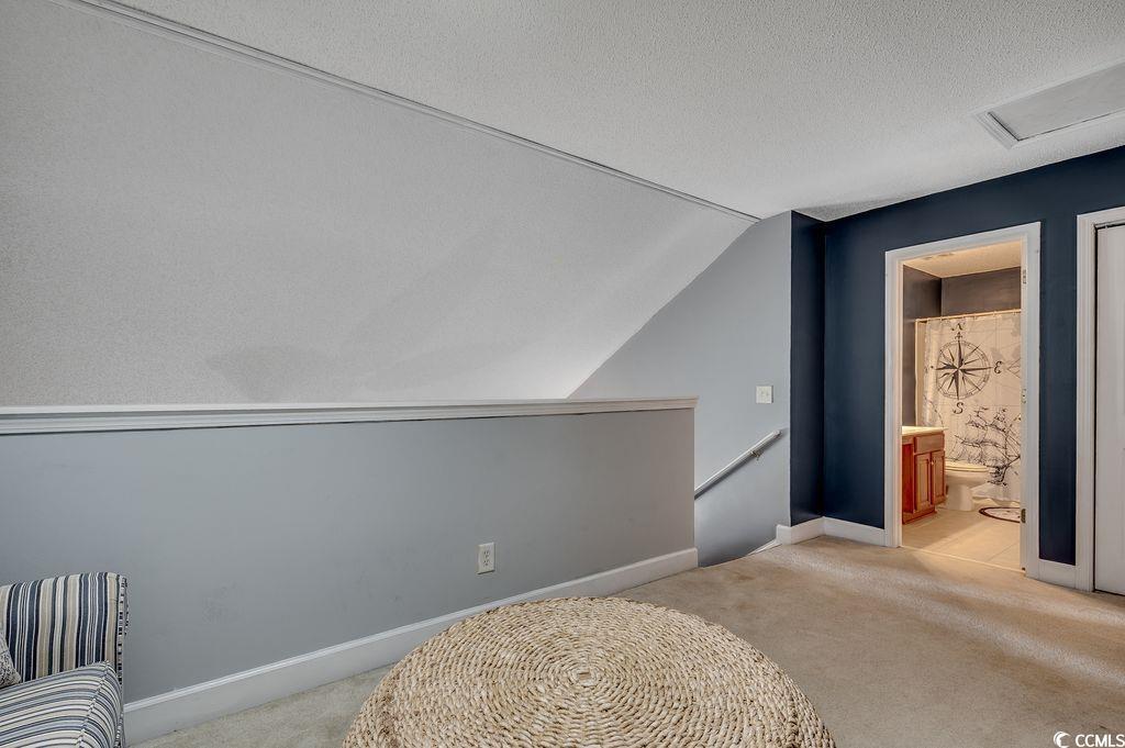 100 Culpepper Way, Unit 1002 Myrtle Beach, SC 29579 - Photo 18 of 39 Unfurnished bedroom featuring vaulted ceiling, light colored carpet, attic access, a textured ceiling, and ensuite bathroom