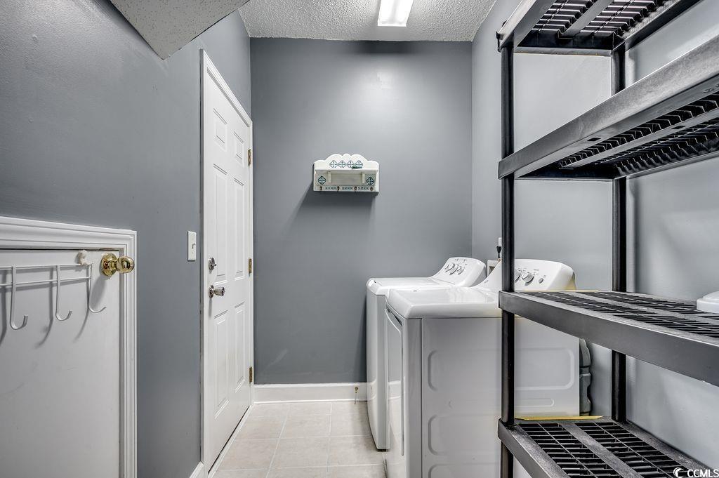 100 Culpepper Way, Unit 1002 Myrtle Beach, SC 29579 - Photo 24 of 39 Laundry area with washer and dryer, a textured ceiling, and tile patterned flooring