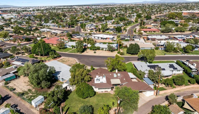 a view of a house with a yard and large tree