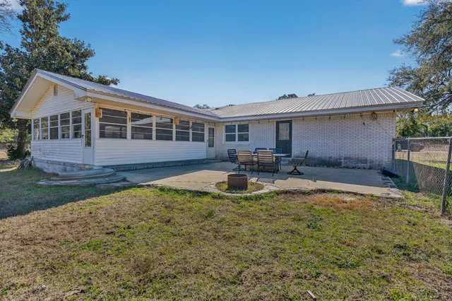 a view of a house with backyard and sitting area