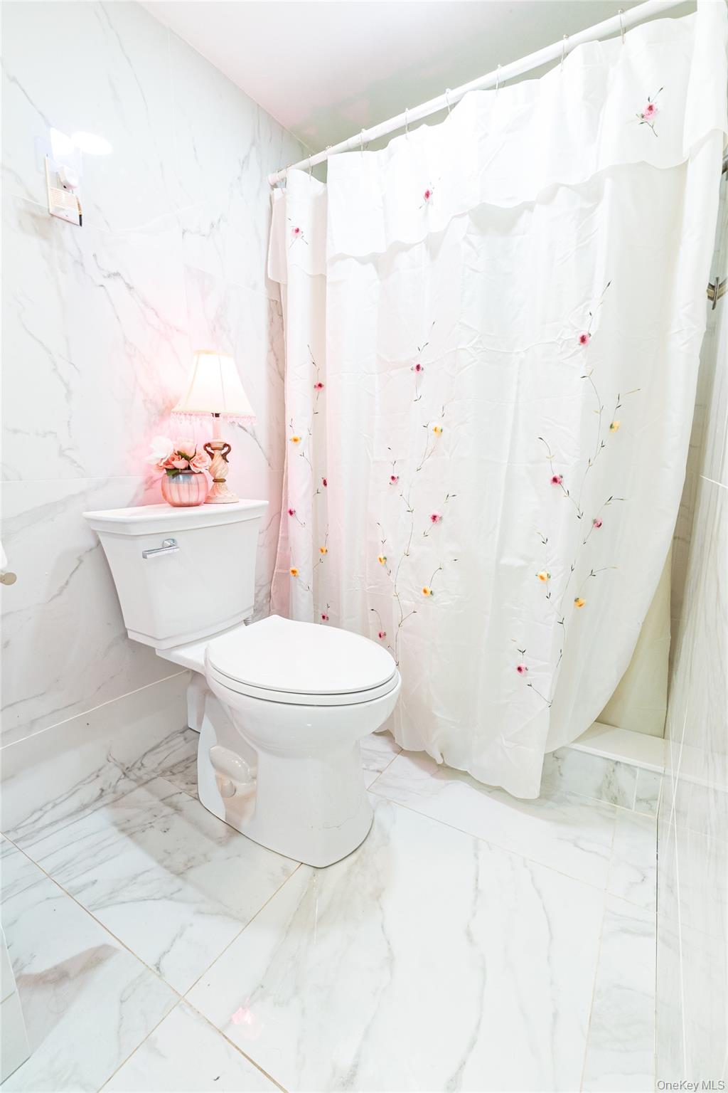 163 Orchard Road East Patchogue, NY 11772 - Photo 15 of 26 Bathroom with stone wall, marble tiled flooring, a shower with curtain, and tile walls