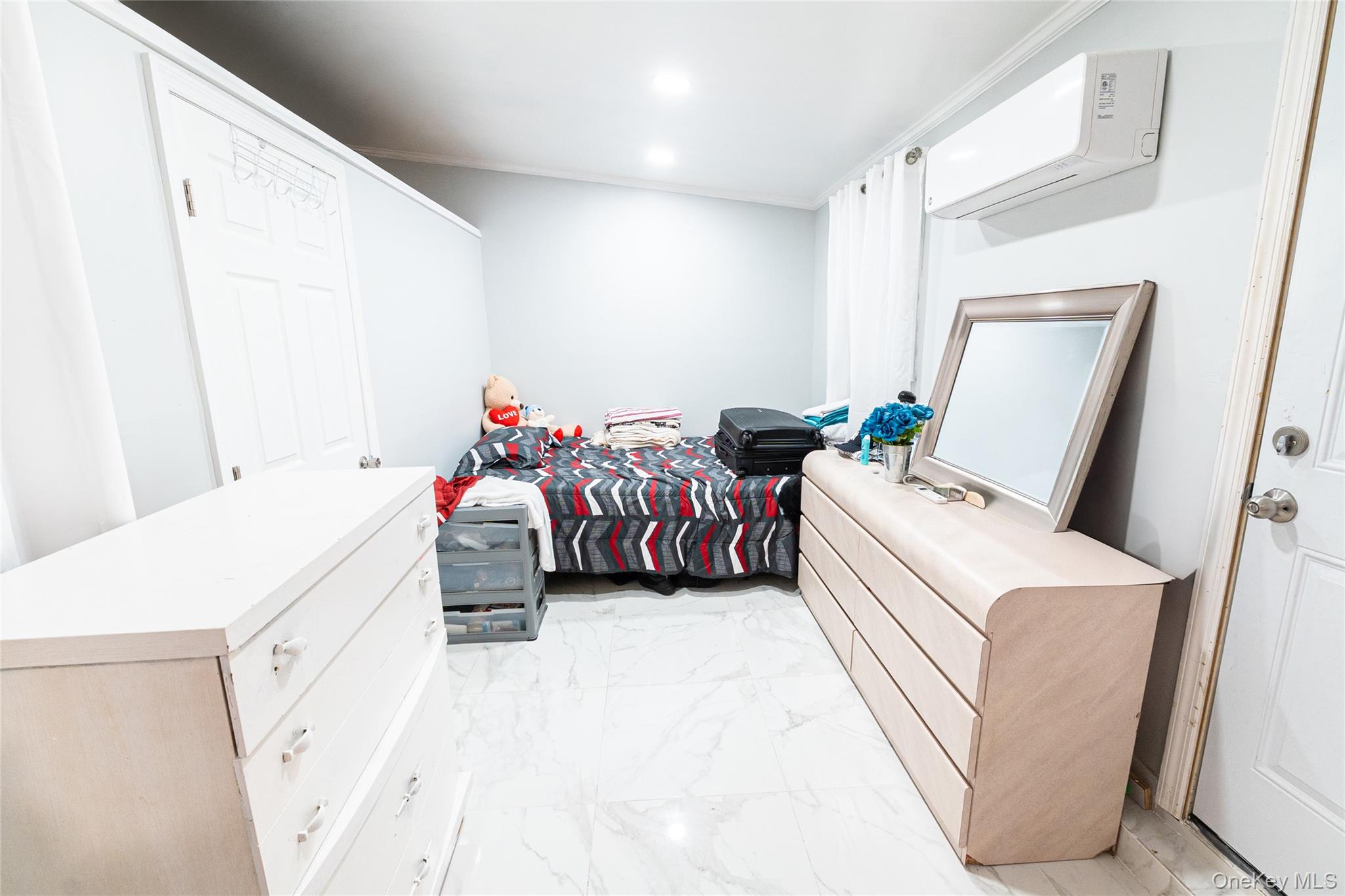 163 Orchard Road East Patchogue, NY 11772 - Photo 17 of 26 Bedroom with light marble finish flooring and an AC wall unit