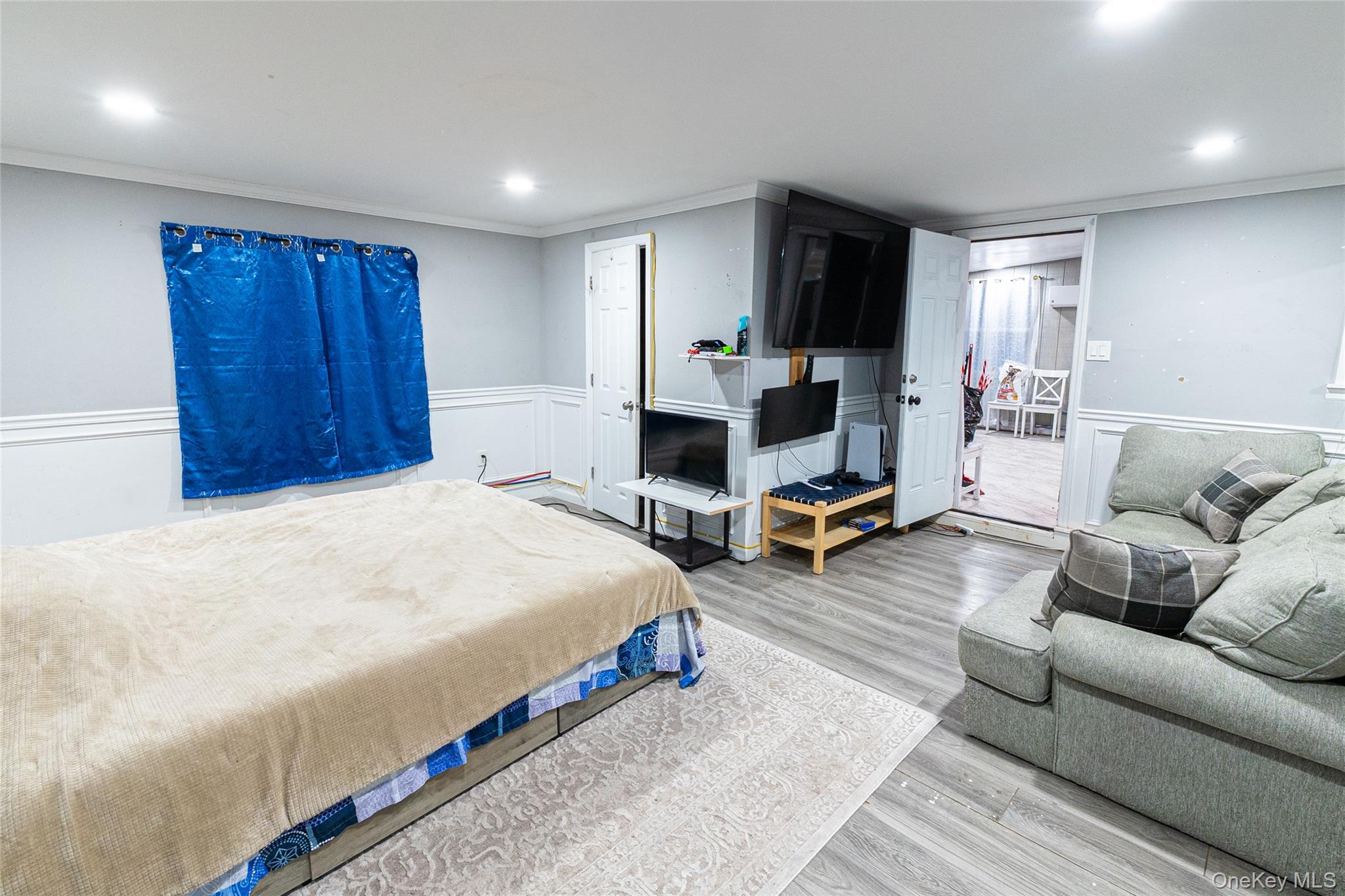 163 Orchard Road East Patchogue, NY 11772 - Photo 23 of 26 Bedroom with crown molding, wood finished floors, wainscoting, and recessed lighting