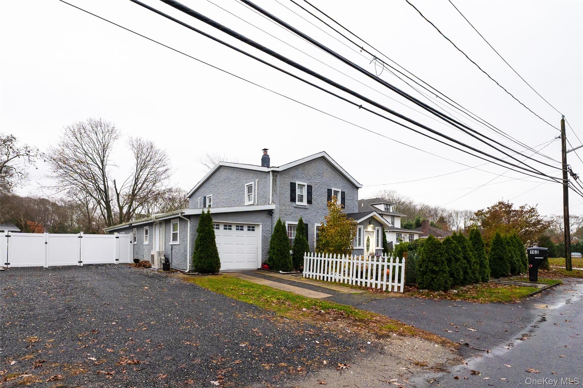 163 Orchard Road East Patchogue, NY 11772 - Photo 3 of 26 View of side of home featuring a gate, a chimney, driveway, and an attached garage