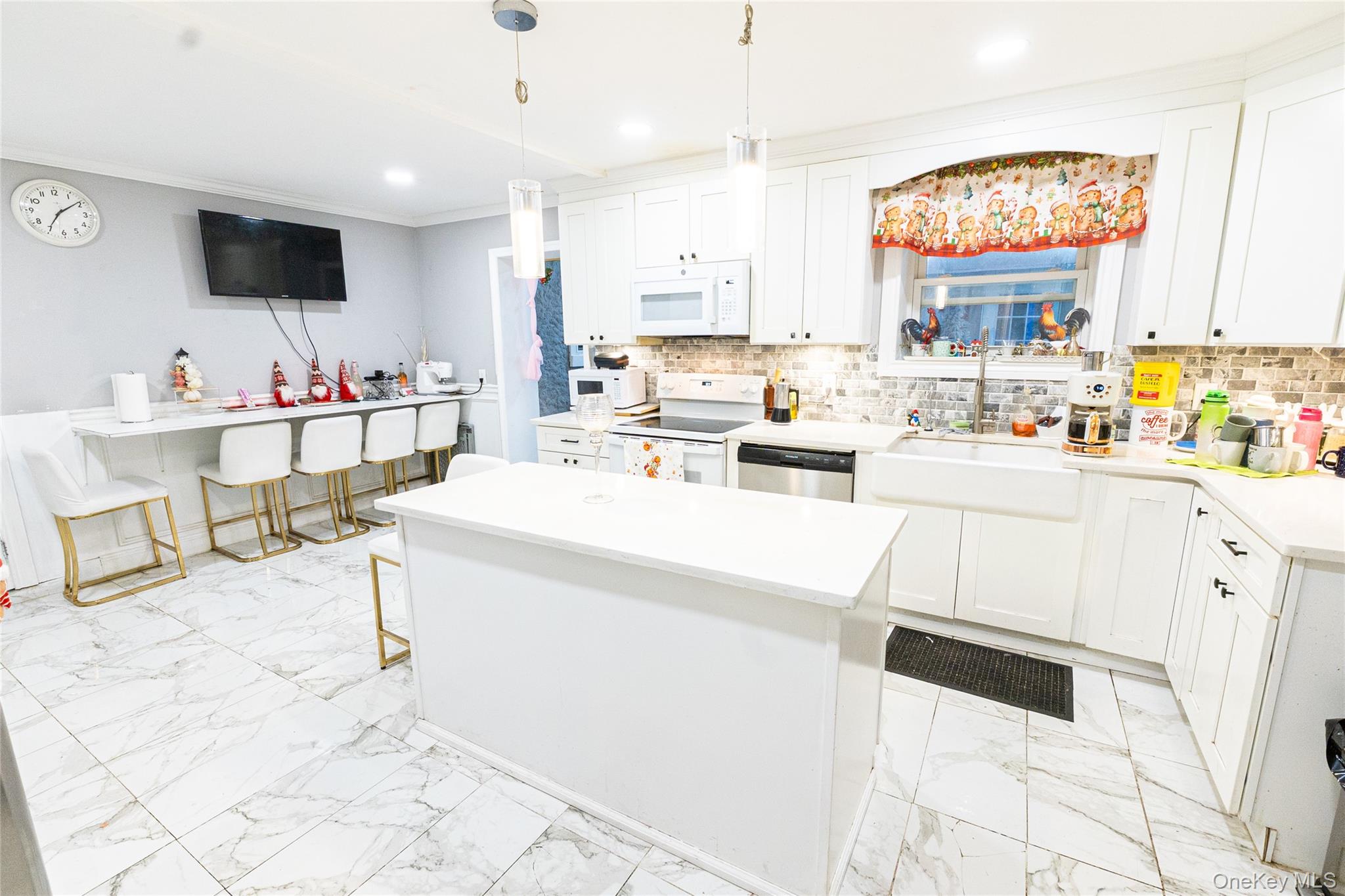163 Orchard Road East Patchogue, NY 11772 - Photo 5 of 26 Kitchen featuring white cabinets, white appliances, crown molding, a center island, and pendant lighting