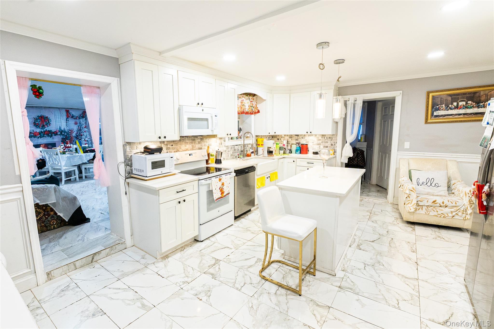 163 Orchard Road East Patchogue, NY 11772 - Photo 7 of 26 Kitchen featuring a wainscoted wall, crown molding, white appliances, white cabinetry, and light marble finish flooring