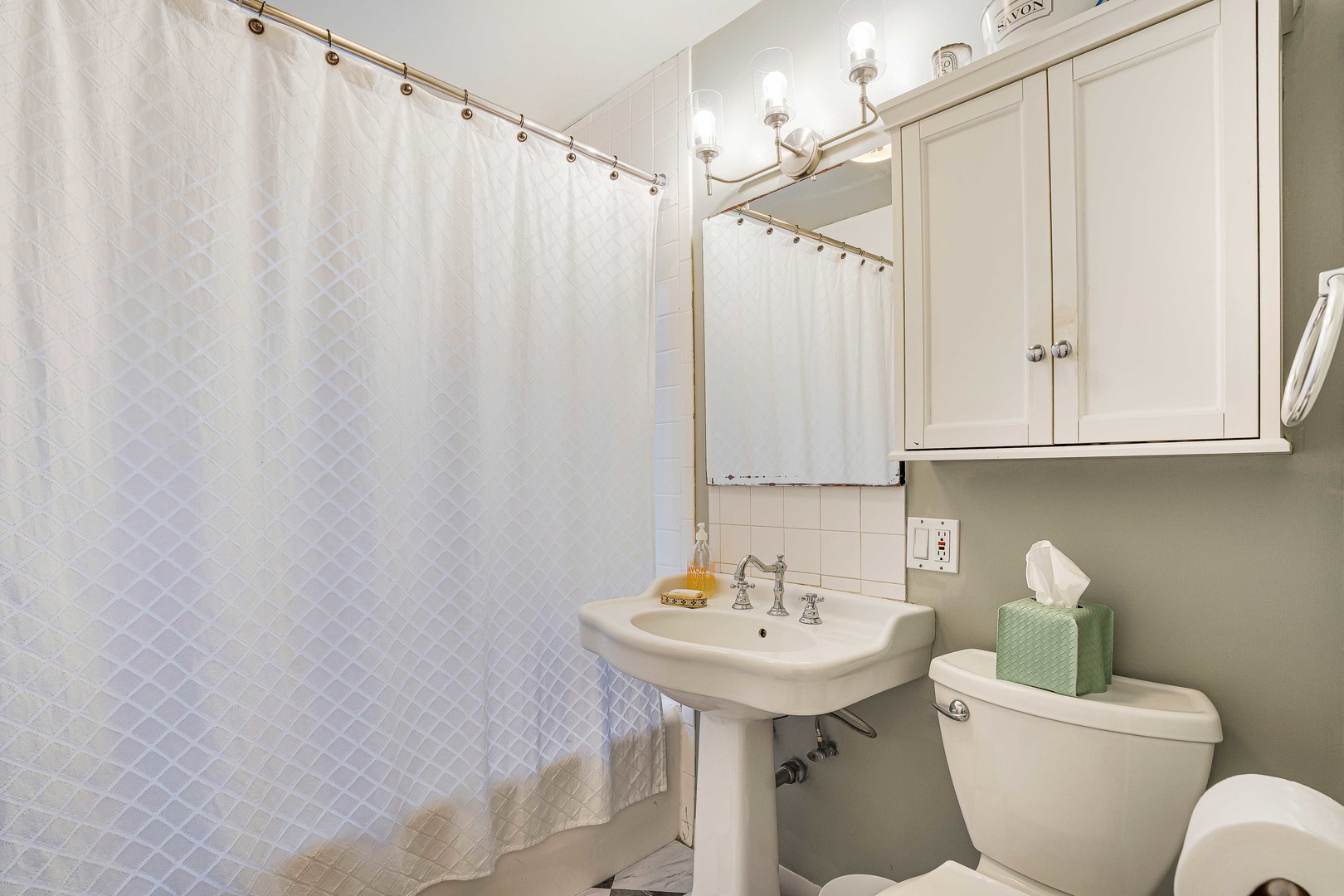 718 West Gordon Terrace, Unit 1F Chicago, IL 60613 - Photo 13 of 13 a bathroom with a sink a toilet and mirror