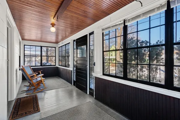a view of a hallway with wooden floor and furniture