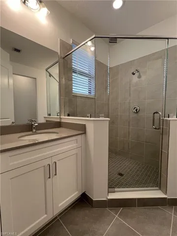 a bathroom with a shower sink and mirror