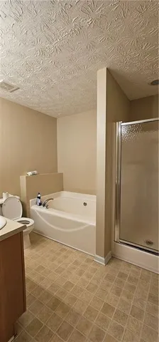 a bathroom with a granite countertop sink a toilet and bathtub