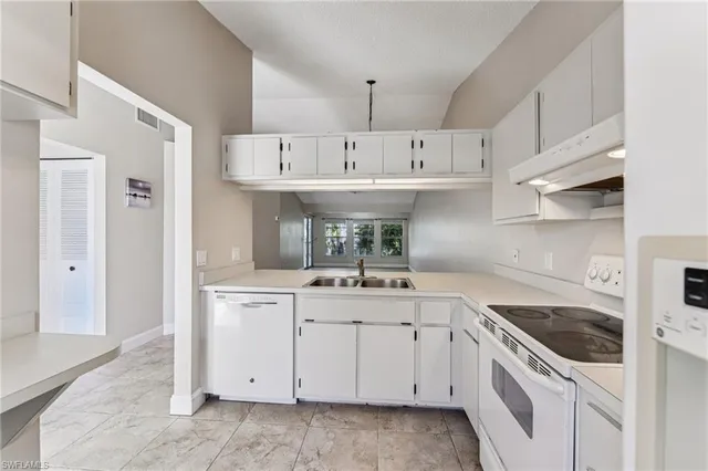a kitchen with a sink stove and cabinets