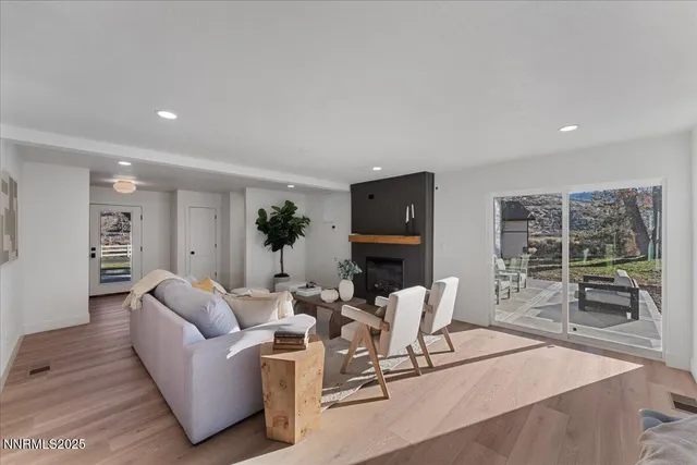 a living room with furniture a large window and a potted plant