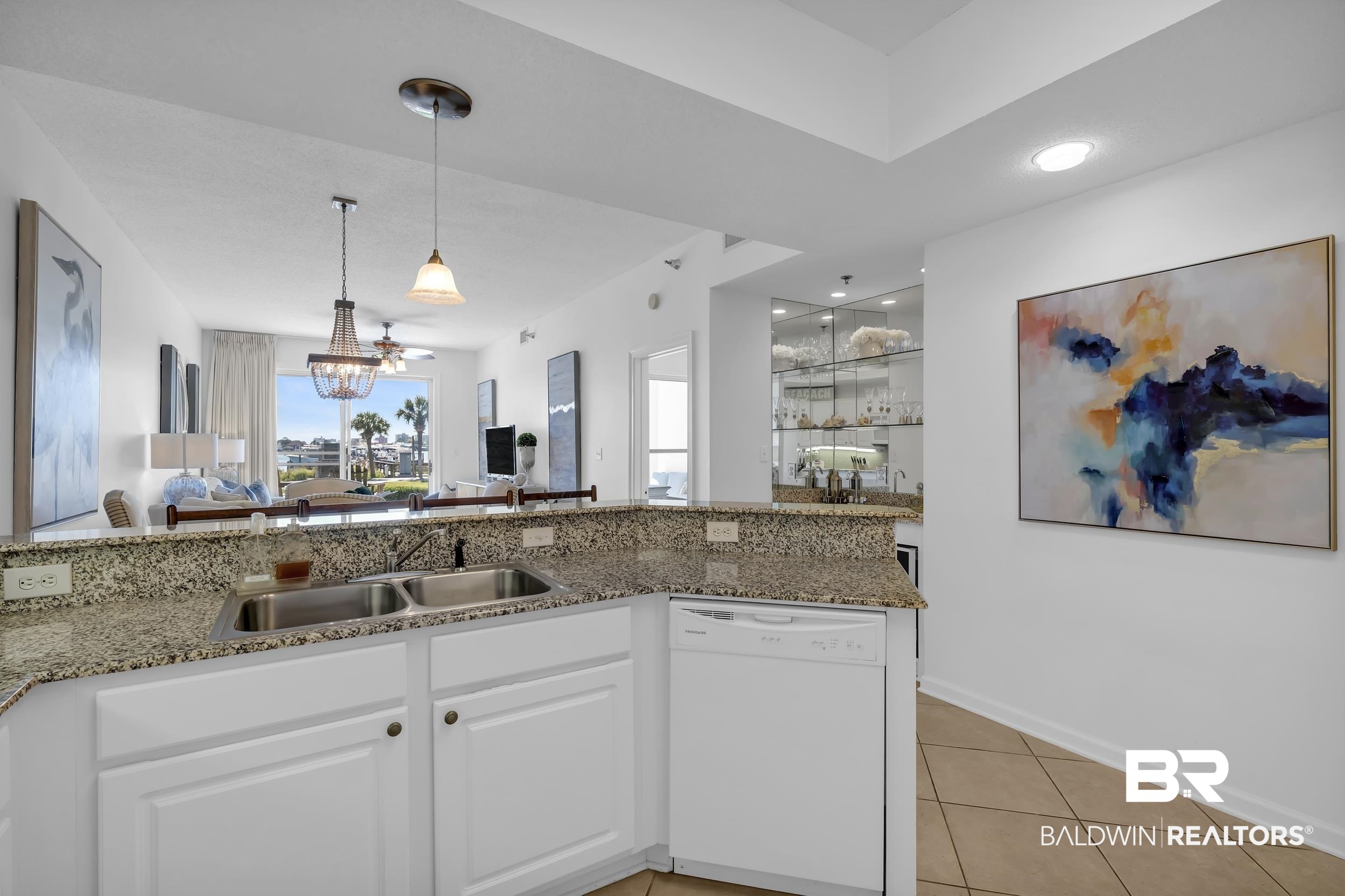 27282 Canal Road, Unit 104 Orange Beach, AL 36561 - Photo 16 of 79 Kitchen featuring white dishwasher, light tile patterned floors, light stone countertops, white cabinetry, and pendant lighting