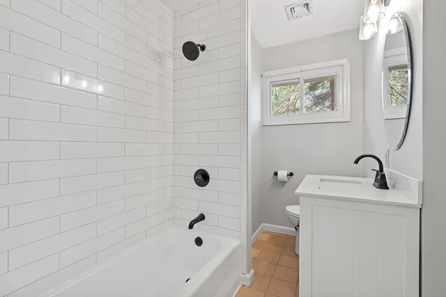 a bathroom with a tub sink and mirror