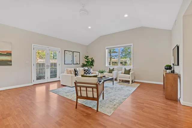 a living room with furniture a window and wooden floor