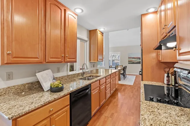a kitchen with stainless steel appliances granite countertop a sink a stove counter space and cabinets