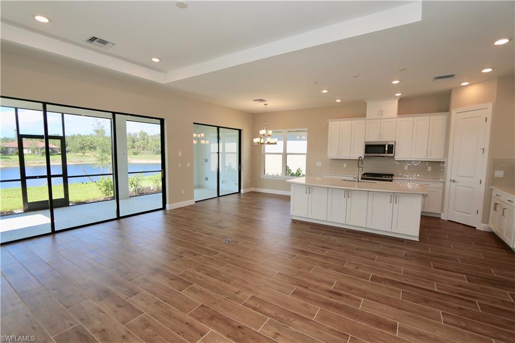 8437 Rosa Court Naples, FL 34114 - Photo 4 of 32 a view of kitchen with refrigerator and wooden floor