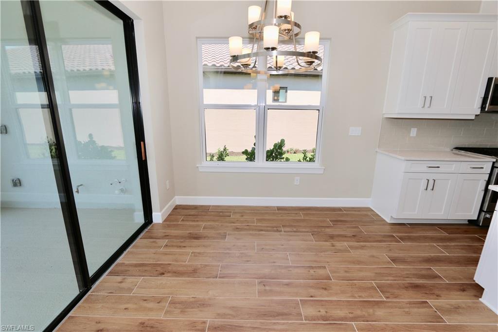 8437 Rosa Court Naples, FL 34114 - Photo 6 of 32 a view of empty room with window and wooden floor