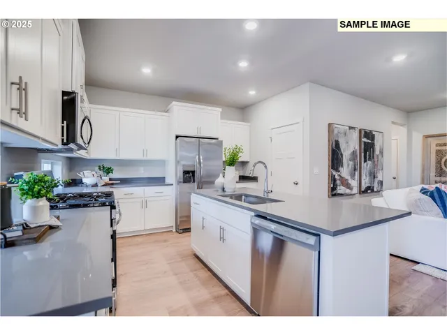 a kitchen with stainless steel appliances kitchen island granite countertop a stove a sink a microwave a dining table and chairs