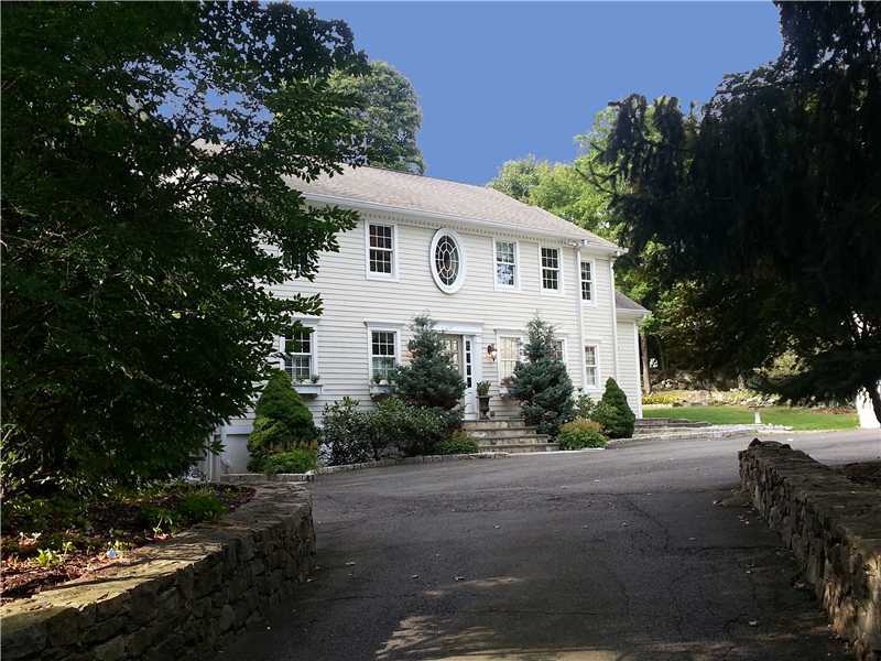 16 Locust Hill Road Darien, CT 06820 - Photo 2 of 25 a front view of a house with a yard and trees