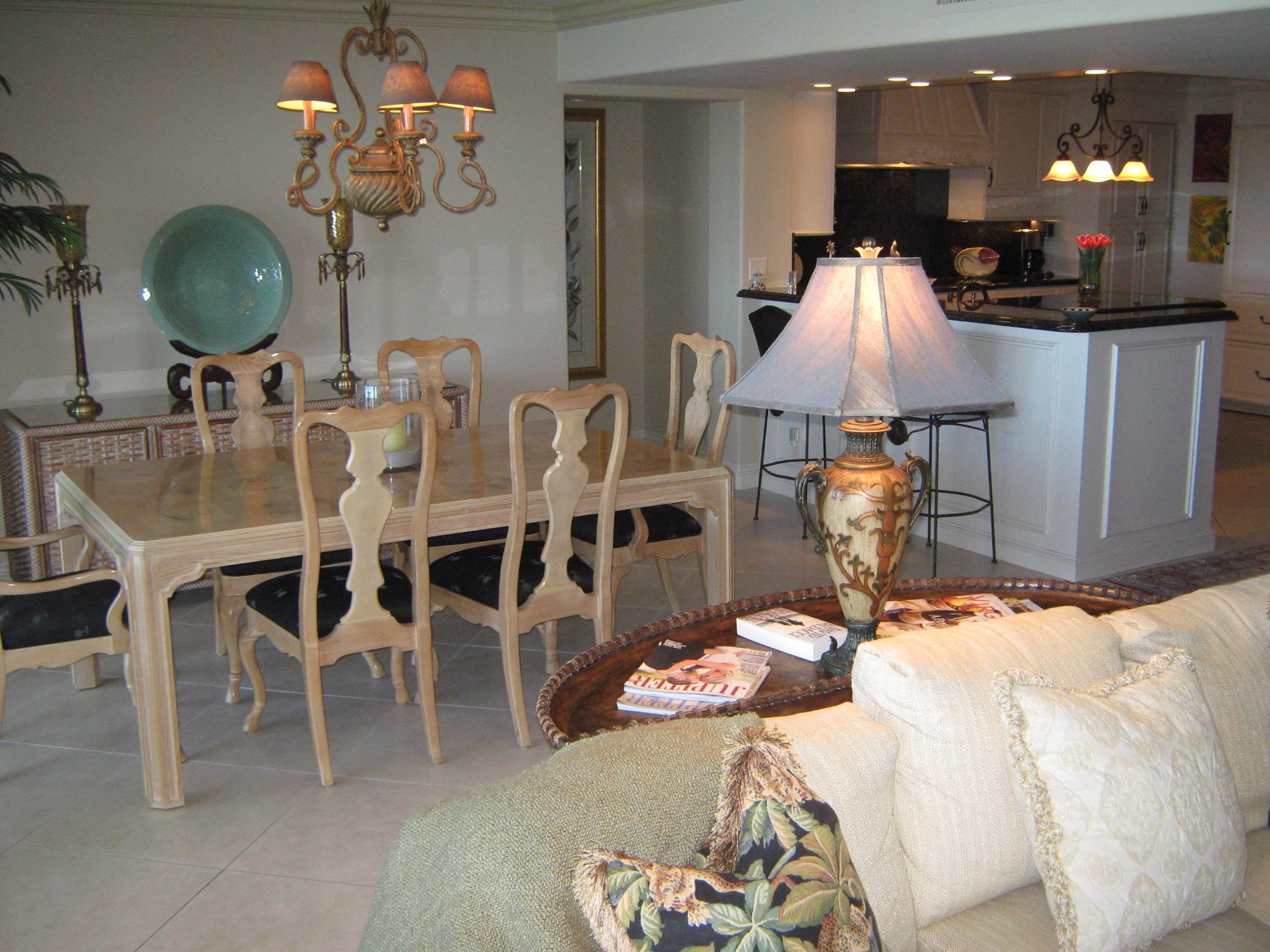 19670 South Beach Road, Unit PHB4 Jupiter, FL 33469 - Photo 15 of 35 a kitchen with a dining table chairs sink and living room view