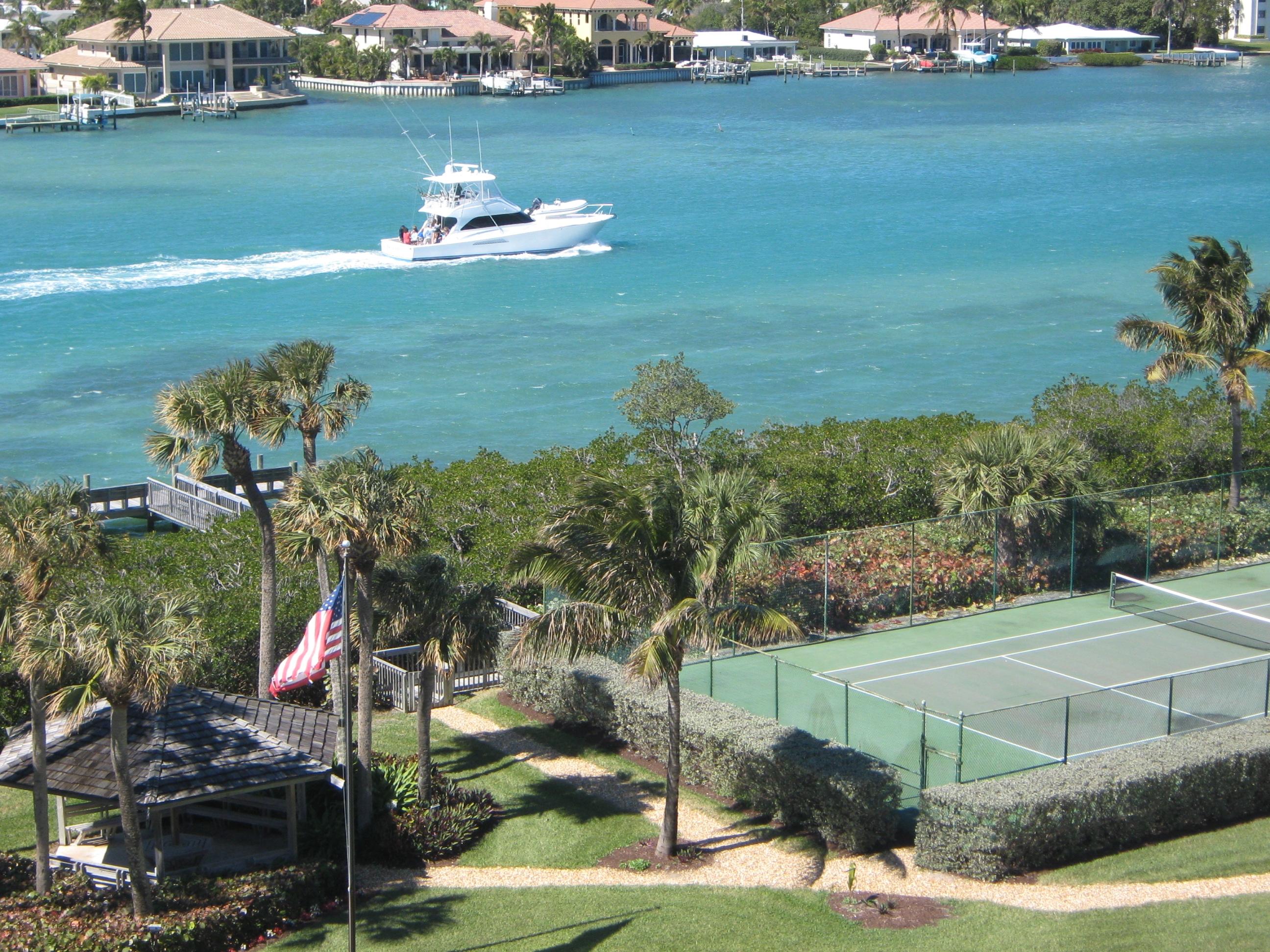 19670 South Beach Road, Unit PHB4 Jupiter, FL 33469 - Photo 9 of 35 a view of a lake with lawn chairs and large trees