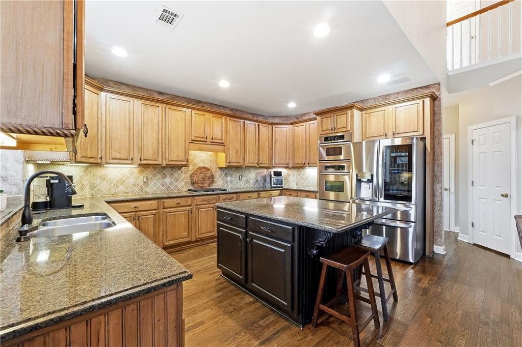 585 Tilbury Drive Suwanee, GA 30024 - Photo 13 of 46 a kitchen with stainless steel appliances granite countertop a sink a stove and a refrigerator