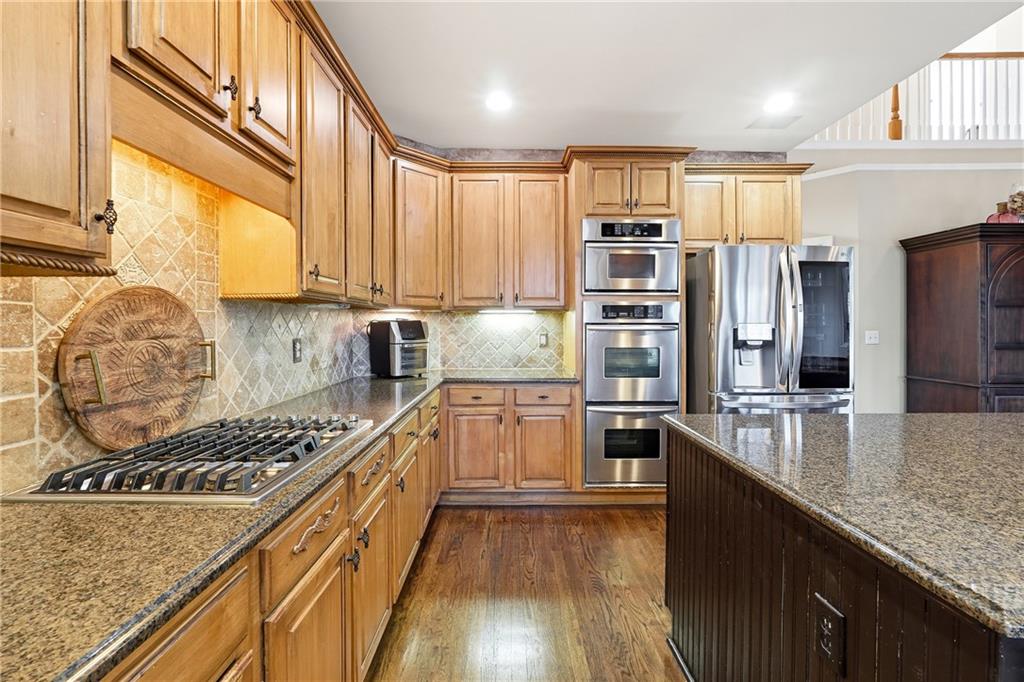 585 Tilbury Drive Suwanee, GA 30024 - Photo 17 of 46 a kitchen with kitchen island granite countertop a stove and cabinets